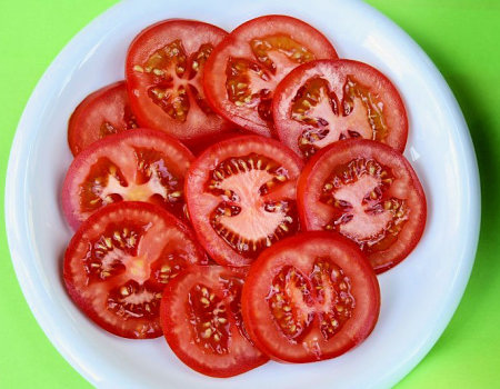 Pomidory pokroisz w równe plasterki...