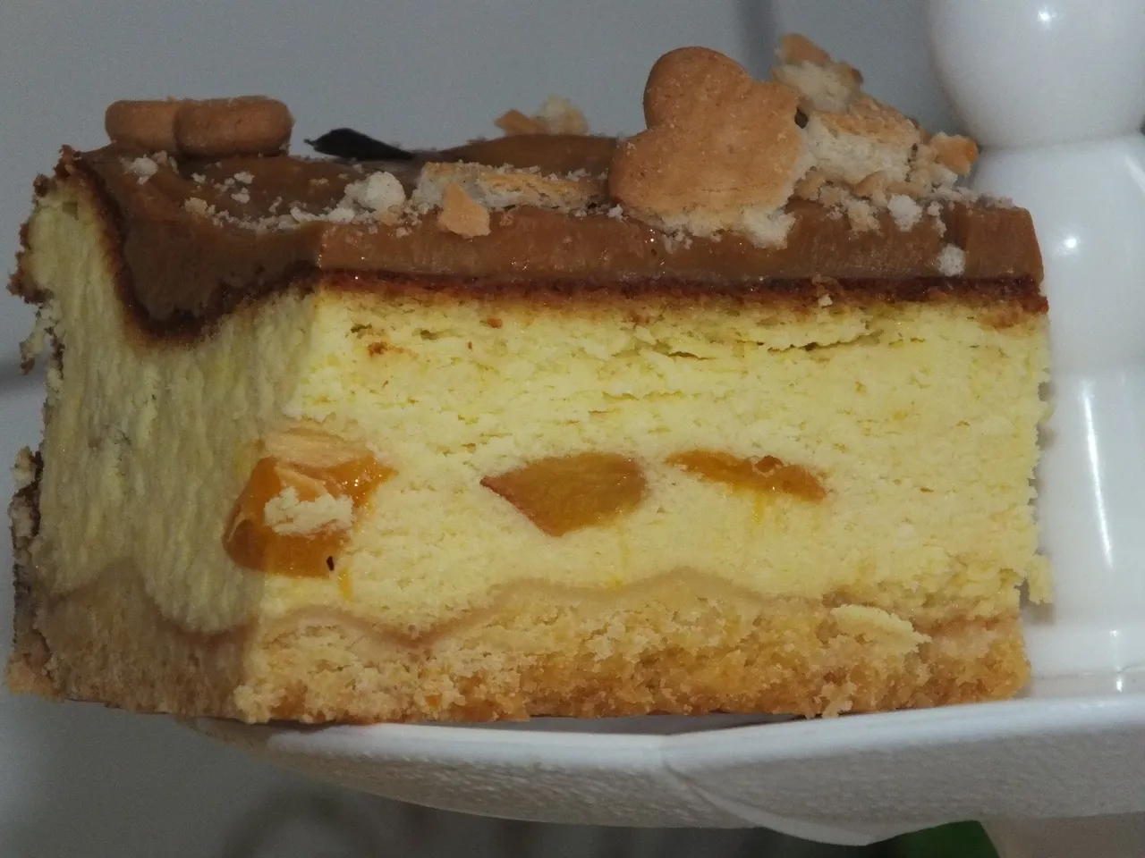 Sernik z brzoskwiniami, karmelową polewą i herbatnikami