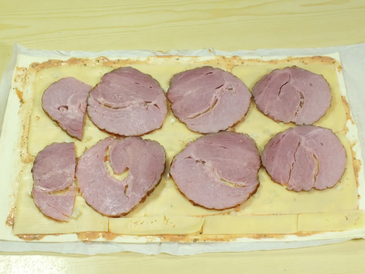 Ślimaczki z ciasta francuskiego z żółtym serem i szynką
